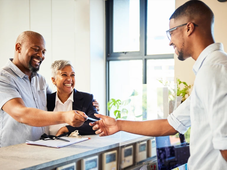 happy hotel guests checking out at front desk